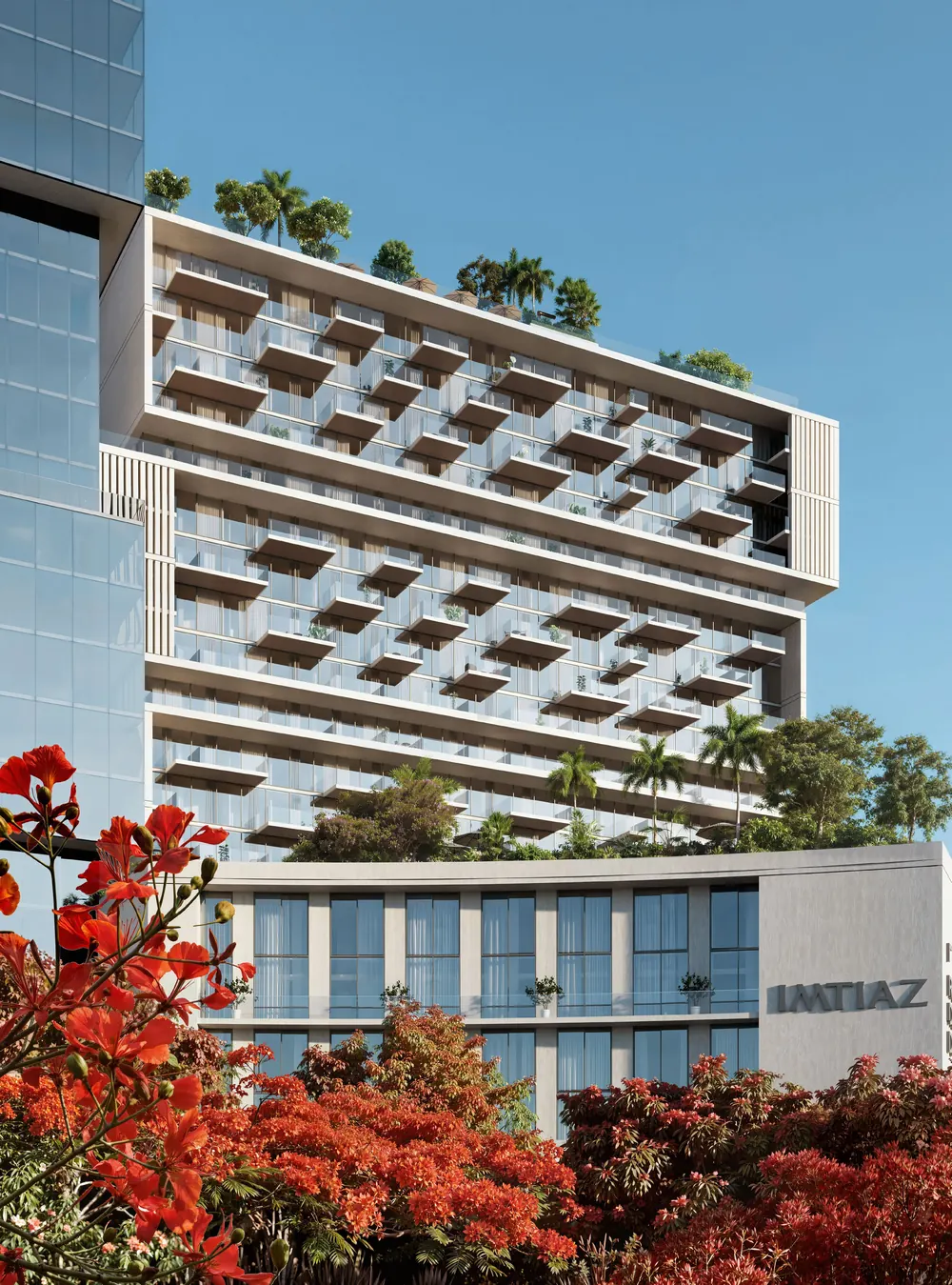 An Imtiaz residential building with cantilevered balconies above red flowering trees